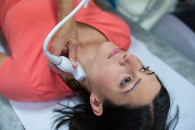 woman getting ultrasound thyroid from doctor